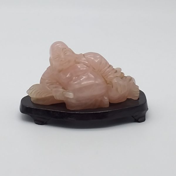 Buddha scolpito in un unico blocco di Quarzo rosa su base di legno.